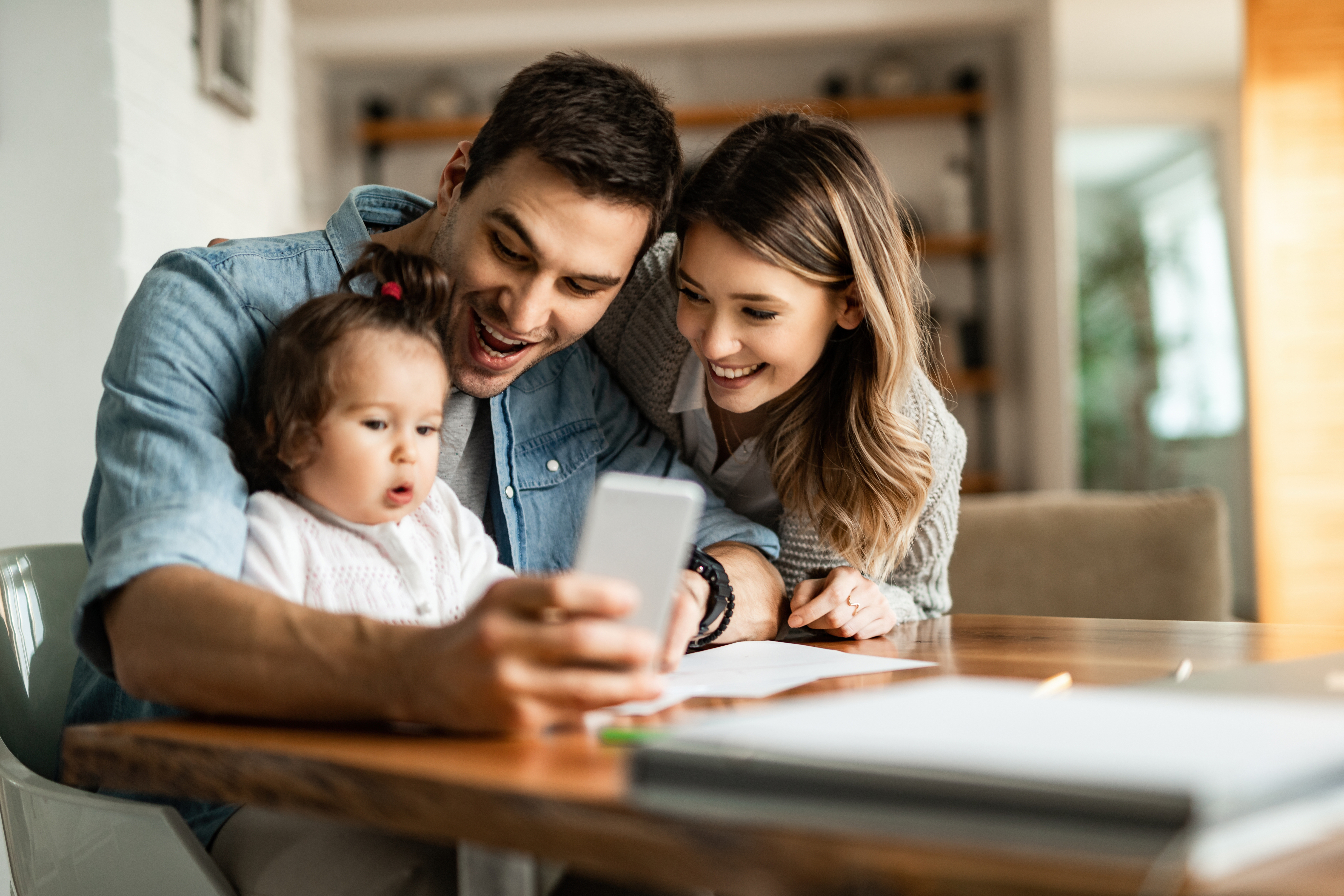 Young couple smiling together at a laptop at home — GENCO Kasasa Checking lifestyle photo