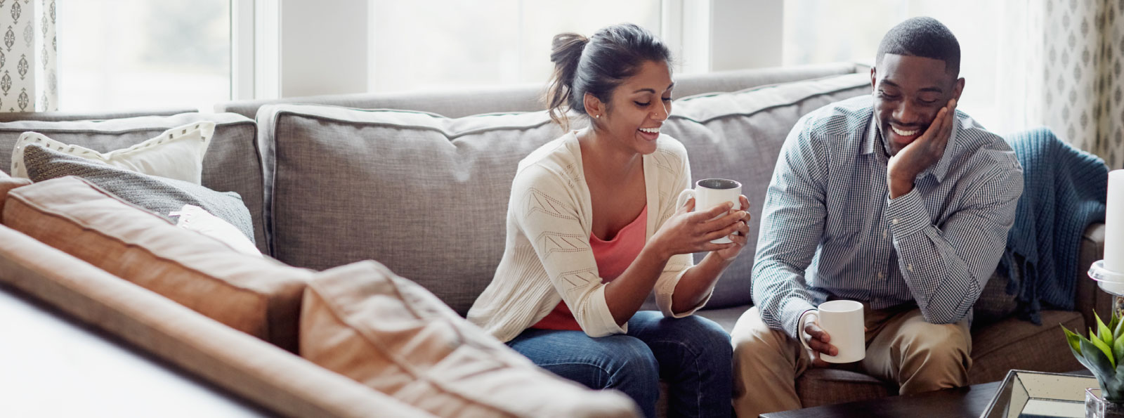 a smiling couple sitting on their couch