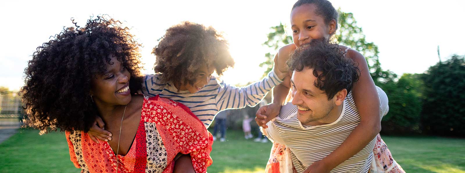 Couple giving kids piggyback rides.